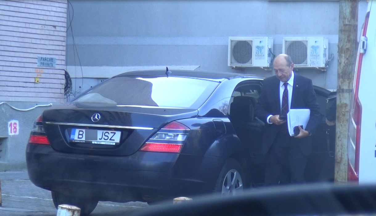 Traian Băsescu iese din maşină, cu un plic şi mai multe hârtii în mână