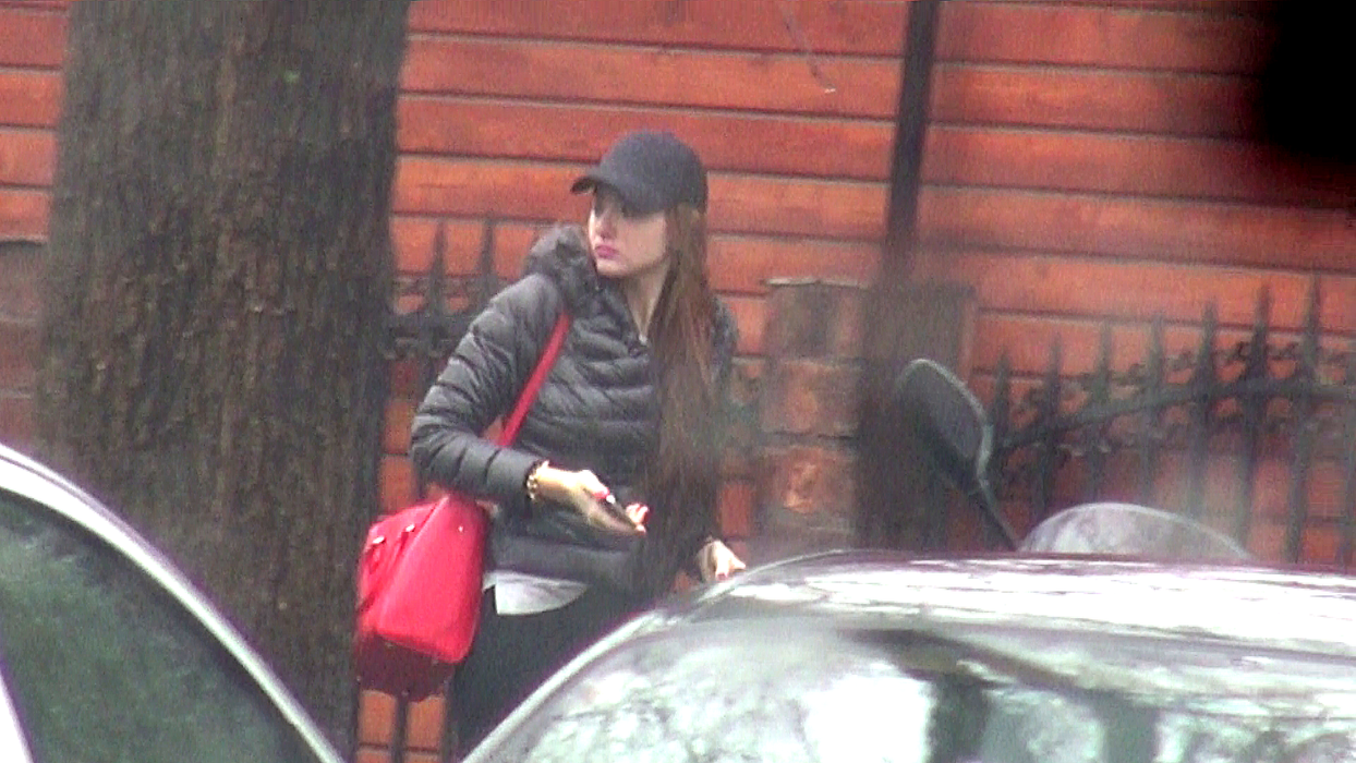 Tânăraşi-a asortat geanta de culoare roşu aprins cu ghetuţele sport, lacul de unghii şi rujul