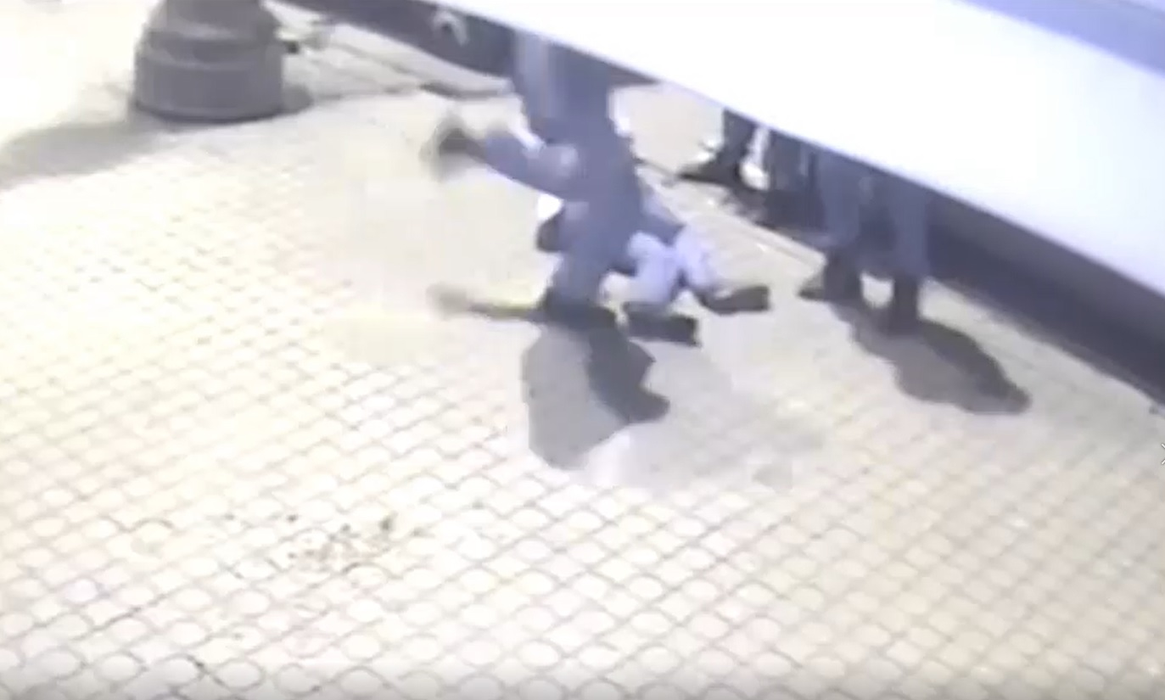 Unul dintre bărbați este lovit cu picioarele, chiar dacă nu se mai mișcă