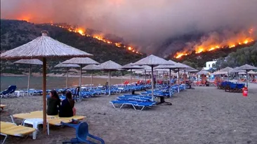 Pleci in Grecia in vacanta?! Mai gandeste-te... Vezi imaginile care te vor face sa lesini de frica - Turistii stau pe sezlonguri la plaja, iar la cativa zeci de metri de ei incendii devastatoare rad padurile