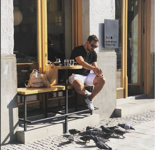 Ștefan Stan, la o terasă, hrănind în același timp și porumbeii