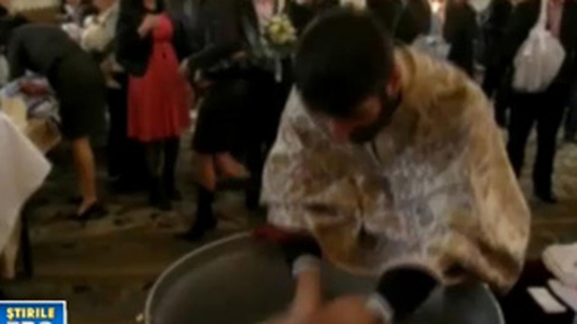 VIDEO Preot acuzat de tentativa de omor, dupa ce era sa inece o fetita in cristelnita, la botez!