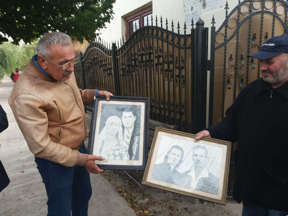 Consilierul local Mihai Dinu și verișorul primar al lui Ilie Balaci, arătând fotografii cu bunicii fotbalistului