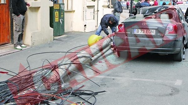 Masina avariata de un stalp care a cazut peste ea