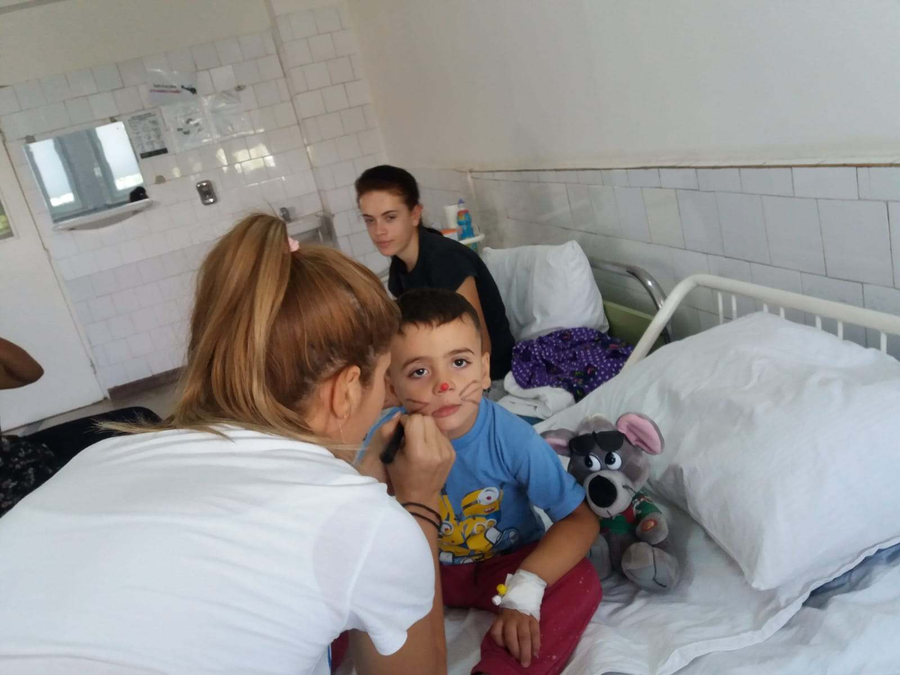 Copiii internați în spital sunt pictați pe față, iar astfel le revine mai repede zâmbetul pe buze