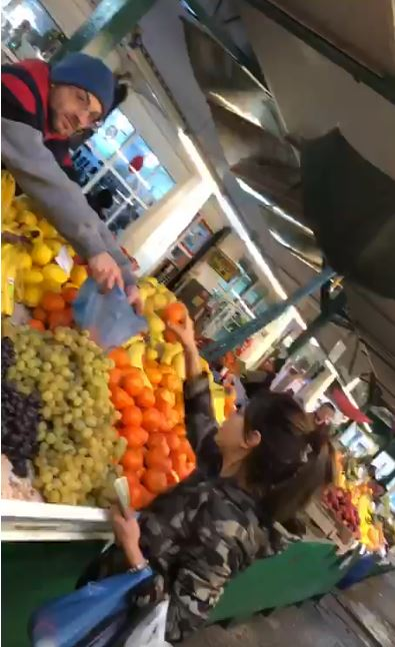 Ana Maria își alege mandarinele, pe care le pune în plasă