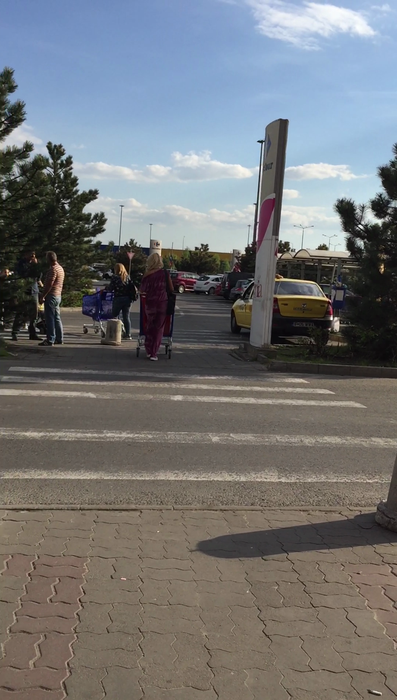 Alina se îndreaptă spre parcarea hypermarket-ului