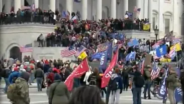 Steagul României, cu gaură la mijloc, precum la Revoluție, fluturat în mulțimea de la Capitoliu