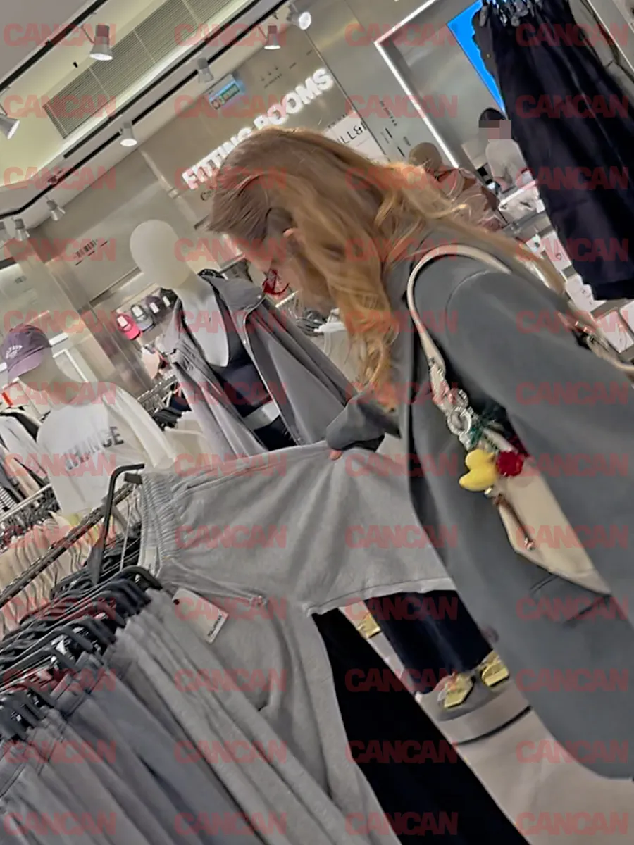 Oana alege o pereche de pantaloni gri pe care îi arată partenerului ei