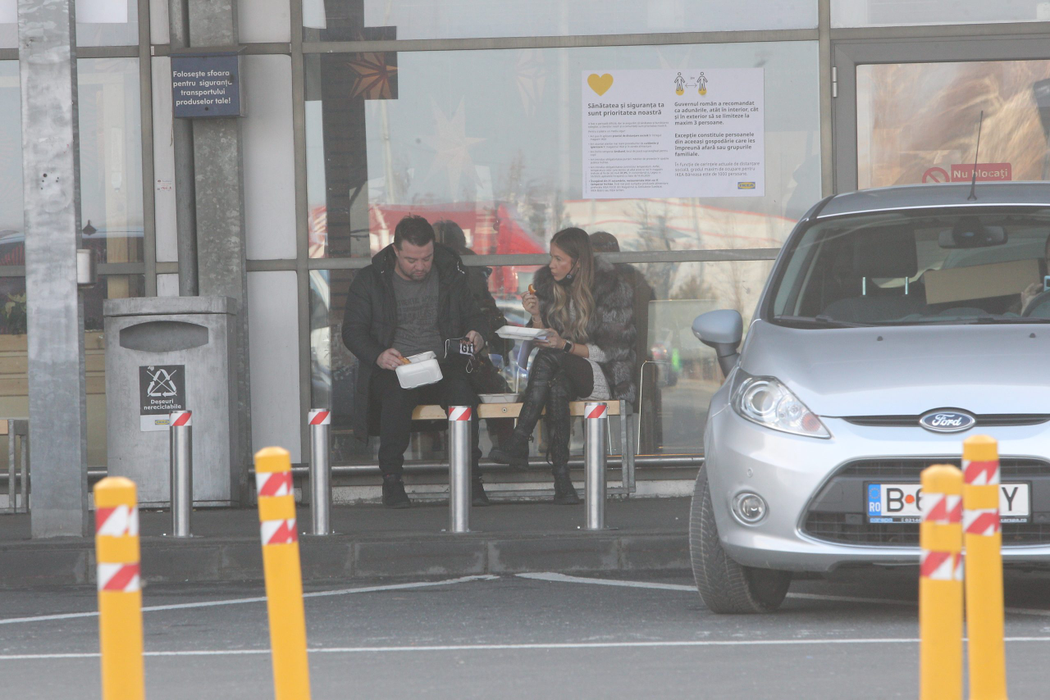 Andrei și Grațiela Duban înfulecă hotdog pe o bancă, la Ikea