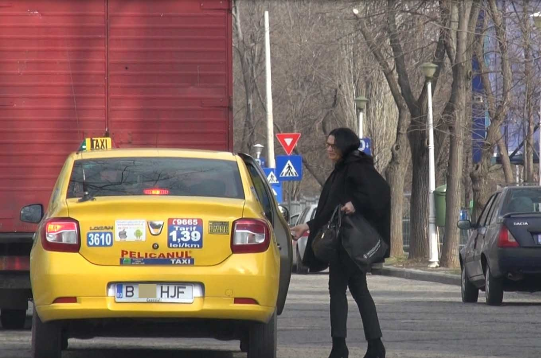 O femeie şi un bărbat, sosiţi cu un taxi, se alătură grupului