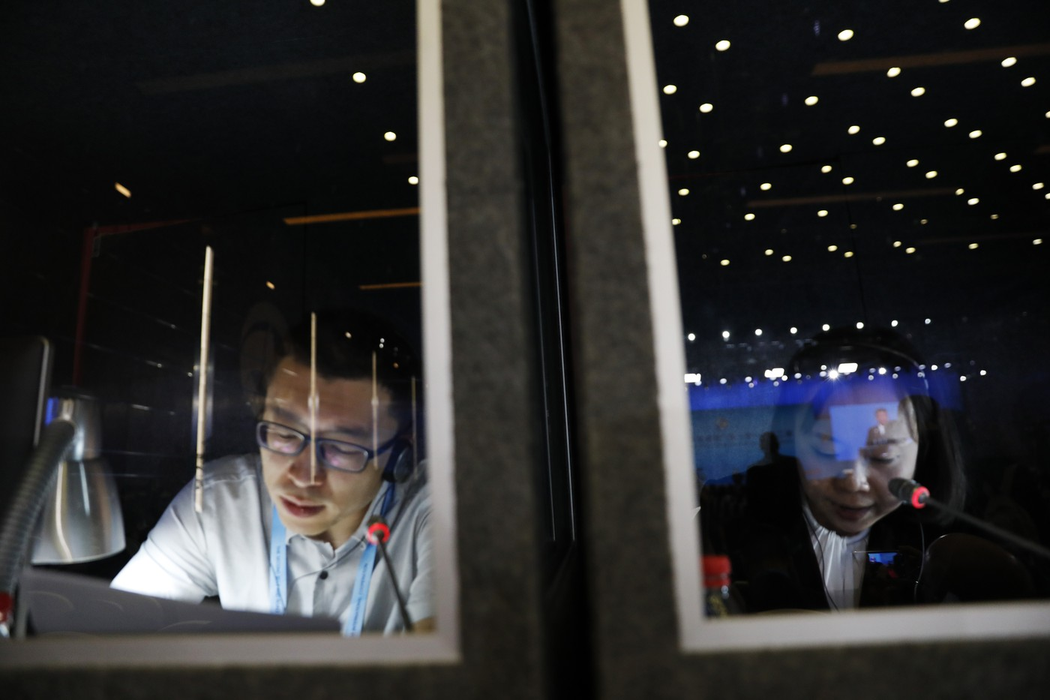 Interpreții lucrează în cabina lor în timp ce președintele chinez Xi Jinping își ține discursul la ceremonia de deschidere a celui de-al doilea Forum Belt and Road pentru Cooperare Internațională (BRF) de la Beijing, vineri, 26 aprilie 2019. Foto: Profimedia