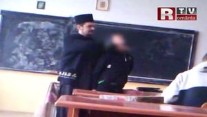 Imagini incredibile! Un preot din Suceava a fost filmat în timp ce-i aplica o corecţie "chinezească" unui elev în faţa clasei!