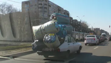 Parca ar fi Familia Flinstone! Se plimba prin Bucuresti cu “baloti” de sticle intr-o Dacie din alta epoca!