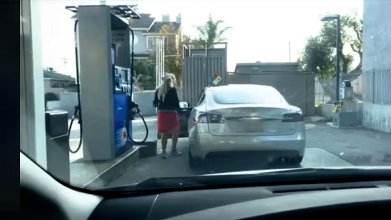 Te tăvălești de râs! O blondă vrea să bage benzină, deși mașina e electrică! Ce i-au făcut doi tineri aflați în spatele ei VIDEO
