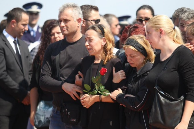 Soția polițistului, distrusă de durere, la înmormântare