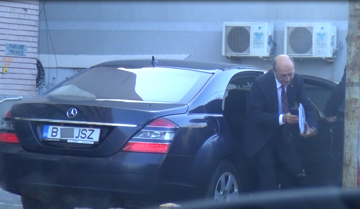 Traian Băsescu iese din maşină, cu un plic şi mai multe hârtii în mână