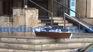 IMAGINI SOCANTE! Un barbat si-a lasat mortul in cosciug, in fata sediului unei banci! Vezi de ce a recurs la acest gest DISPERAT