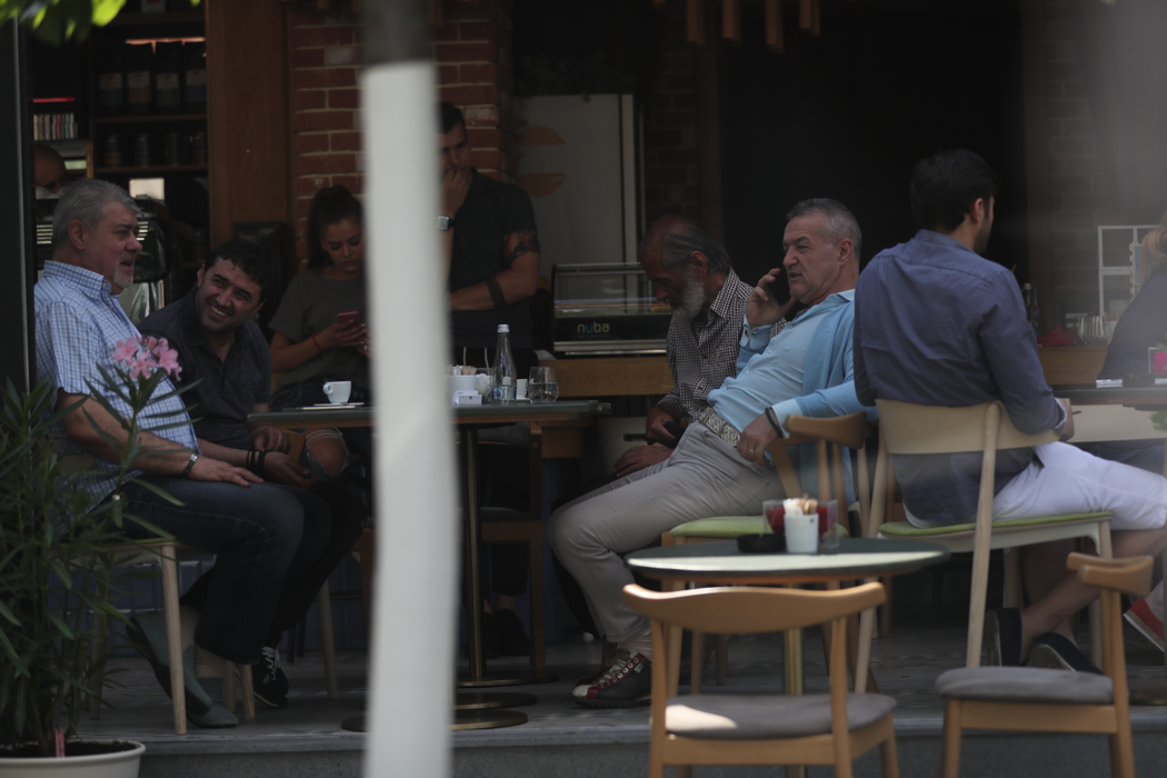 Gigi Becali vorbeşte la telefon. Vizavi de el sunt Luţu şi Vlad Lapte