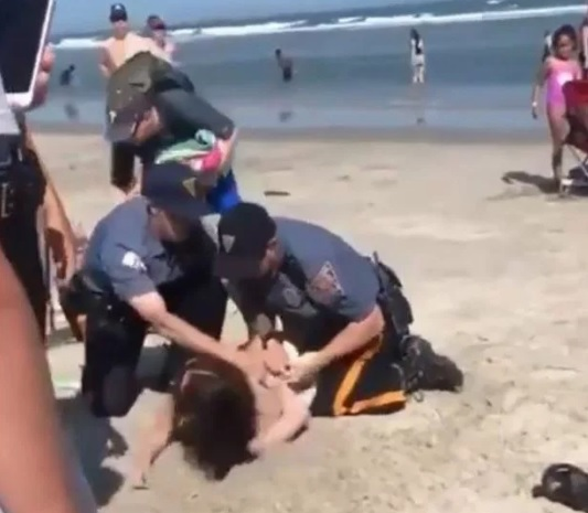 O femeie a fost bătută de polițiști, pe plajă