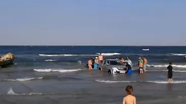 Situatie incredibila pe litoral! 15 oameni s-au chinuit sa scoata un jeep din mare!