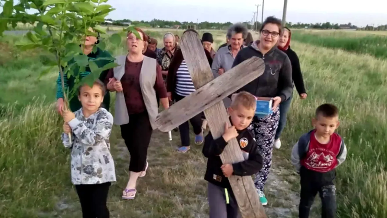 Un copil din Bărăgan a fost pus să care o cruce grea din lemn, într-un ritual de invocare a ploii