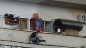 Singurul loc unde nu te asteptai sa vezi vreun cocalar facand gratar! Uite-l pe asta cum isi risca viata stand la etajul 7, pe marginea balconului, la cativa centimetri sa cada in gol!