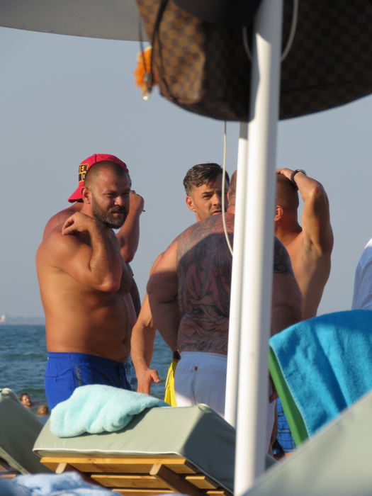 Nuţu (în şort alb) discută pe plajă cu prietenii săi