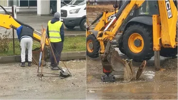 De-a râsu'-plânsu'! „Dorel” din Slatina încearcă să strângă apa cu o lopată, pe stradă, apoi să o răstoarne în cuva unui excavator
