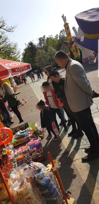 Andra și micuții ei privesc oferta de pe tarabă