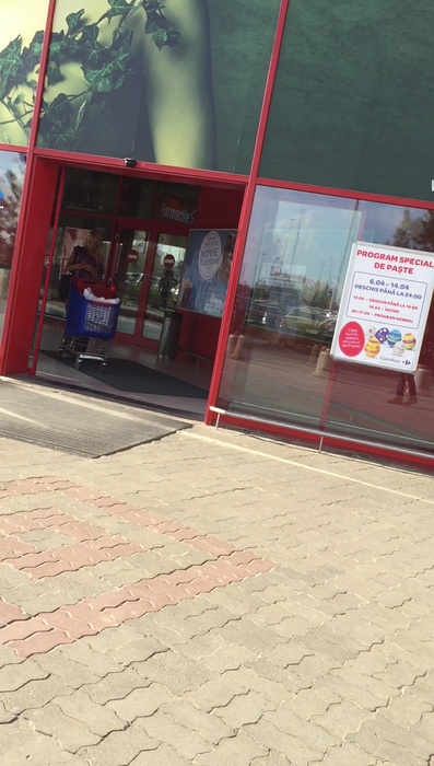 Alina se opreşte în uşa hypermarket-ului pentru a scrie un SMS