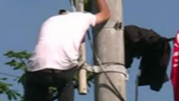 VIDEO Protest ciudat la Cotroceni: S-a catarat pe un stalp cu o sfoara la gat si ameninta ca se arunca! Vrea sa vorbeasca numai cu Traian Basescu!