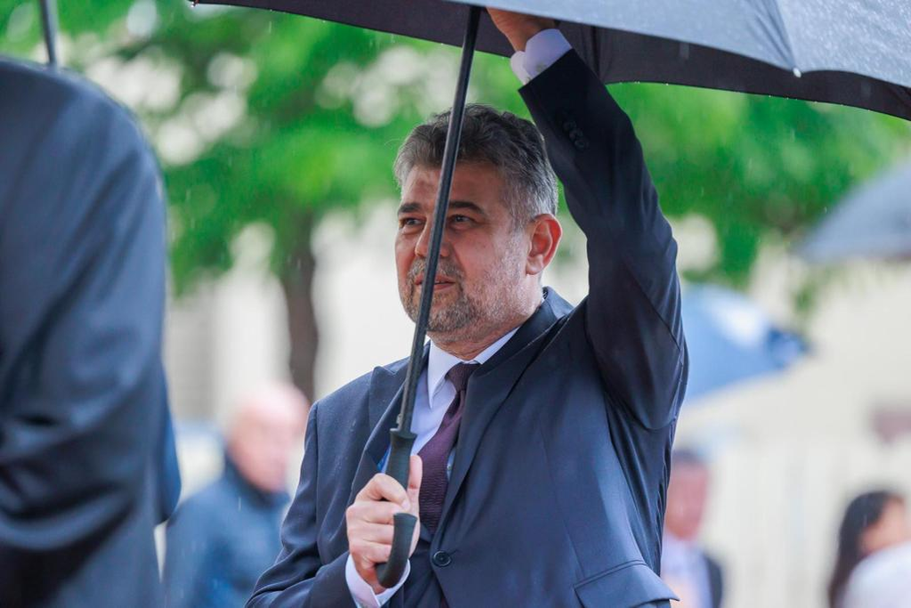 Premierul Marcel Ciolacu și-a ținut singur umbrela, fără să uzeze de protocol