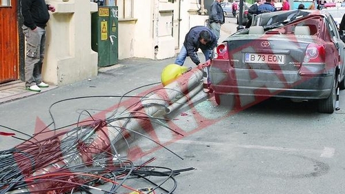 Masina avariata de un stalp care a cazut peste ea