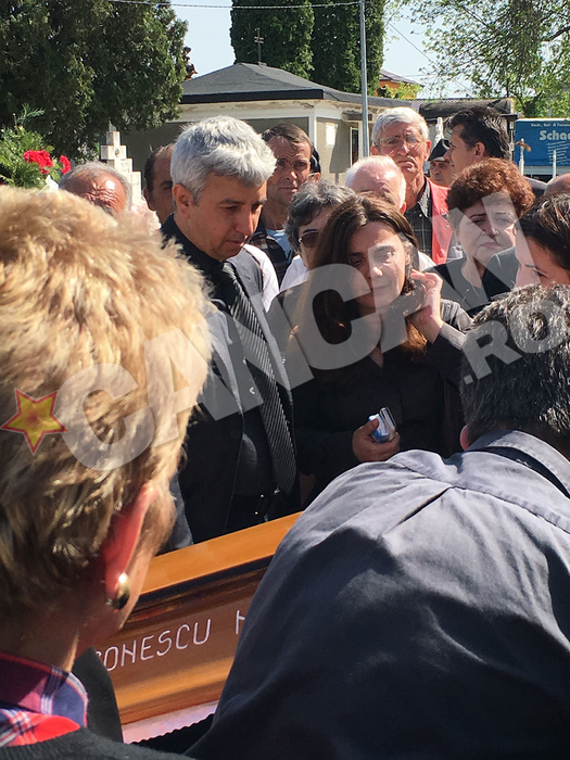 Fostul prezentator priveşte în gol cu ochii pierduţi în direcţia sicriului.