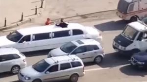 Un muncitor de la asfaltări bea şampanie lângă o limuzină, pe un bulevard din Craiova