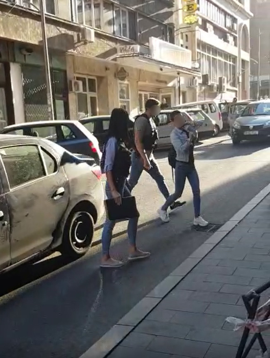 Una dintre suspecte este condusă la audieri de către polițiști