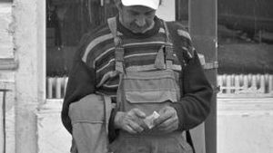 Fotografie emoționantă. Ce scrie pe șapca acestui bărbat din Iași, care ține, trist, în mână, o bancnotă de 1 leu