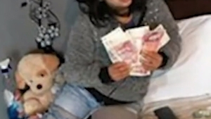 O româncă din Anglia s-a fotografiat într-un pat cu bani. Care era ocupația femeii