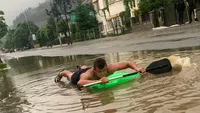 Imagini incredibile suprinse pe o stradă din Vatra Dornei. Un tânăr a făcut „rafting“ într-o baltă care a răsărită după o ploaie torenţială. VIDEO