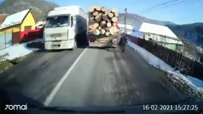 Uluitor! Un bărbat dă cu capul de mașina plină cu bușteni, aflată în mișcare pe stradă! VIDEO