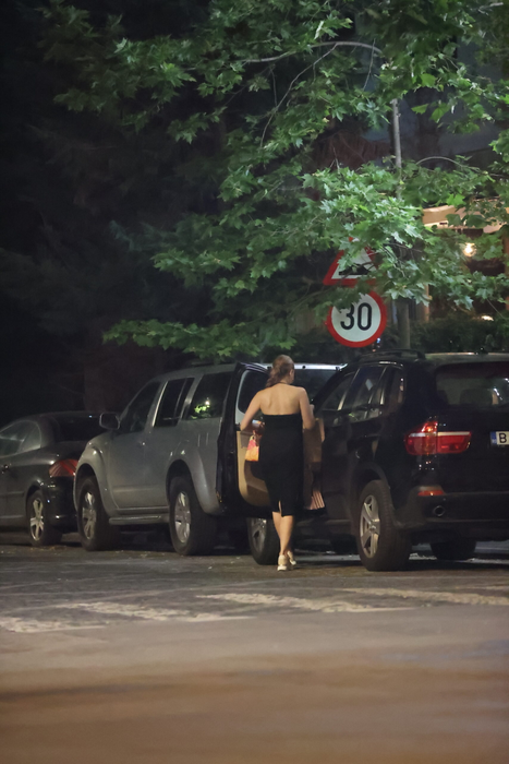 Iulia Vântur se retrage de la terasă, cu plasele în mâini, după ce, în prealabil, făcuse și un scurt shopping (Foto: CANCAN.RO)