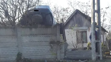 Cascadorie într-o localitate din Dolj. Un șofer băut și fără permis s-a urcat cu maşina pe gardul unei locuinţe