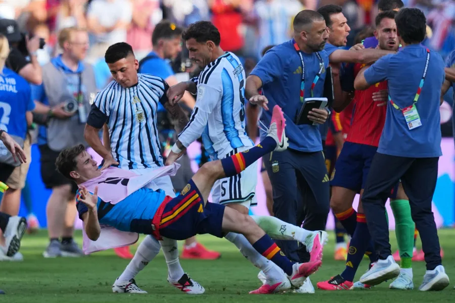 Leandro Paredes îl doboară pe Gavi și membrii staffului tehnic argentinian, în dreapta, se îmbrâncesc cu Eric García din Spania, după finala CM 2026 dintre Spania și Argentina. Sursa foto: Profimedia