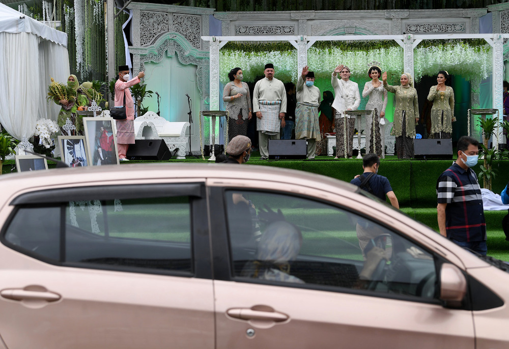 PUTRAJAYA, 20 Dis -- Ahli Parlimen Putrajaya, Datuk Seri Tengku Adnan Tengku Mansor (lima, kanan) dan isteri Datin Seri Anggraini Sentiyaki (dua, kanan) bersama anaknya yang juga pengantin lelaki, Tengku Muhammad Hafiz (tengah) dan isteri Oceane Cyril  Alogia (tiga, kanan) melambai tangan dan beramah mesra dengan tetamu secara pandu lalu pada Majlis Walimatulurus mereka yang mengikut prosedur operasi standard (SOP) bagi mencegah jangkitan COVID-19 dalam tempoh Perintah Kawalan Pergerakan Pemulihan (PKPP) di Dataran Putrajaya hari ini.
--fotoBERNAMA (2020) HAK CIPTA TERPELIHARA