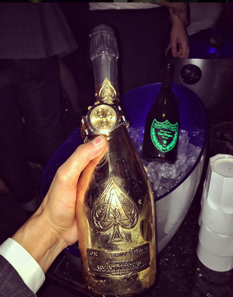 Regele Fiţelor îşi face un sandviş: un Rolex peste o sticlă de Armand de Brignac. Pe fundal se zăreşte şi un Dom Perignon