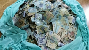 Milioane de lei ascunși în cutii și la saltea, în casa unui traficant de droguri din București