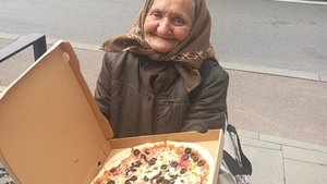 Povestea emoționantă din spatele acestei imagini din Cluj-Napoca. De ce ține această bătrână o pizza în mână