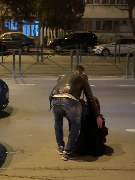 Bărbatul încearcă să-și ridice iubita de pe trotuar