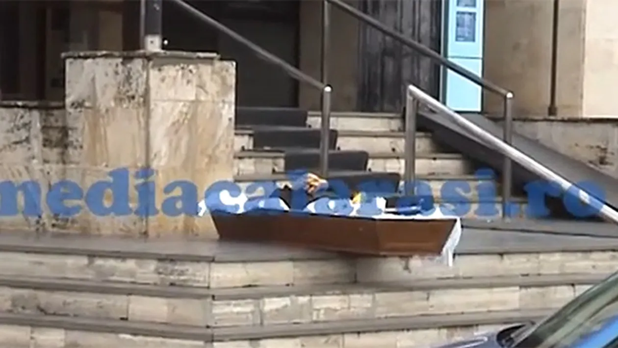 IMAGINI SOCANTE! Un barbat si-a lasat mortul in cosciug, in fata sediului unei banci! Vezi de ce a recurs la acest gest DISPERAT